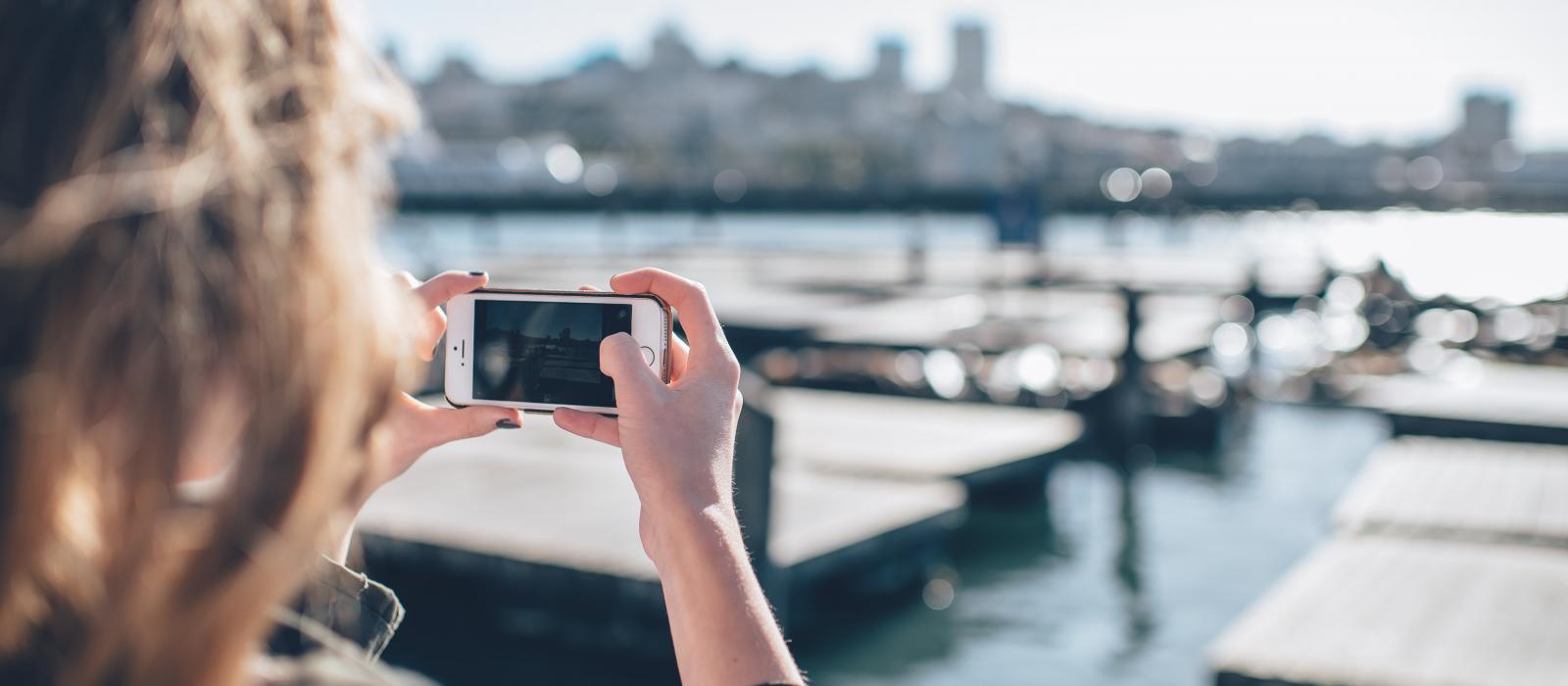 woman takes photo of harbor on iPhone