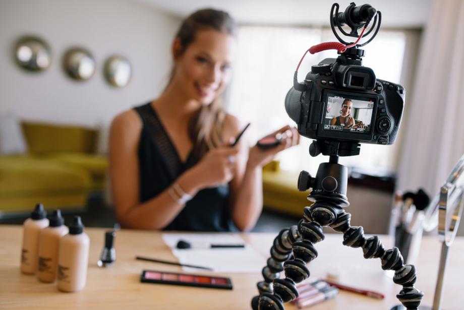 Young female vlogger recording a make-up video for her vlog.